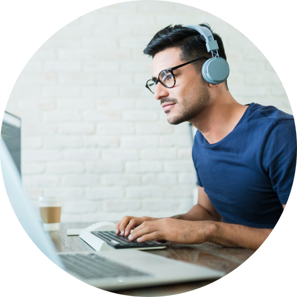 Man at computer listening to focus music on headphones