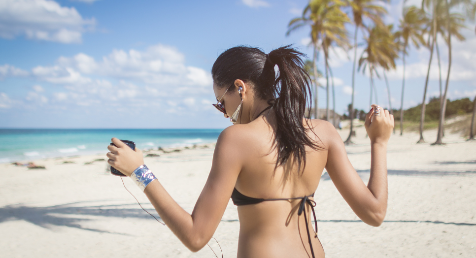 Woman listening to reggaeton on beach