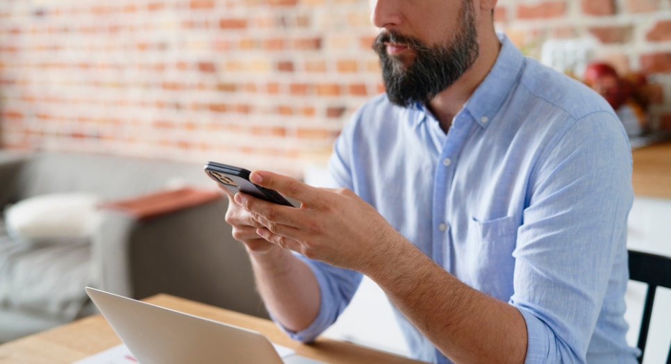 Man searching for focus music on phone at computer