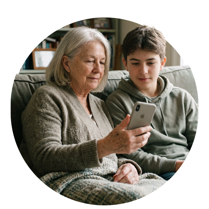 Grandmother and teenage grandson on a sofa, sharing music on an iPhone