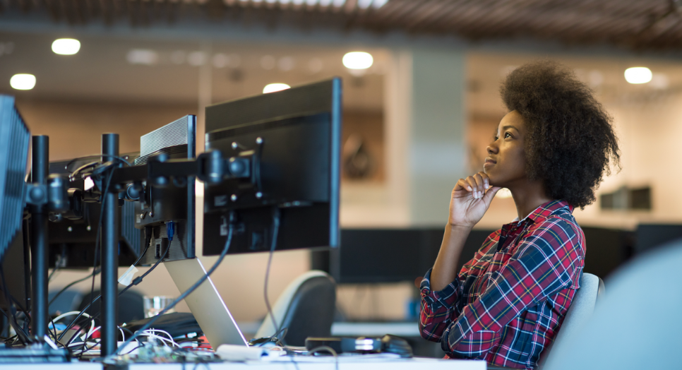 A woman looking at her screen deciding between Feed.fm vs the Spotify API