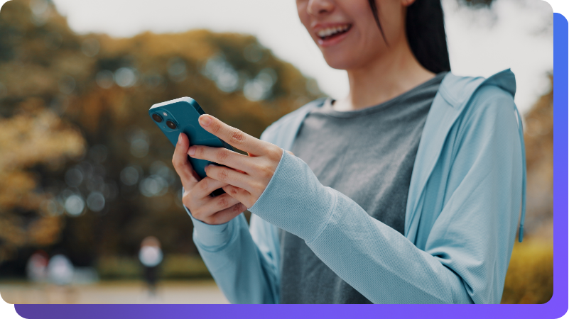 Close up of woman holding phone outside, using social app