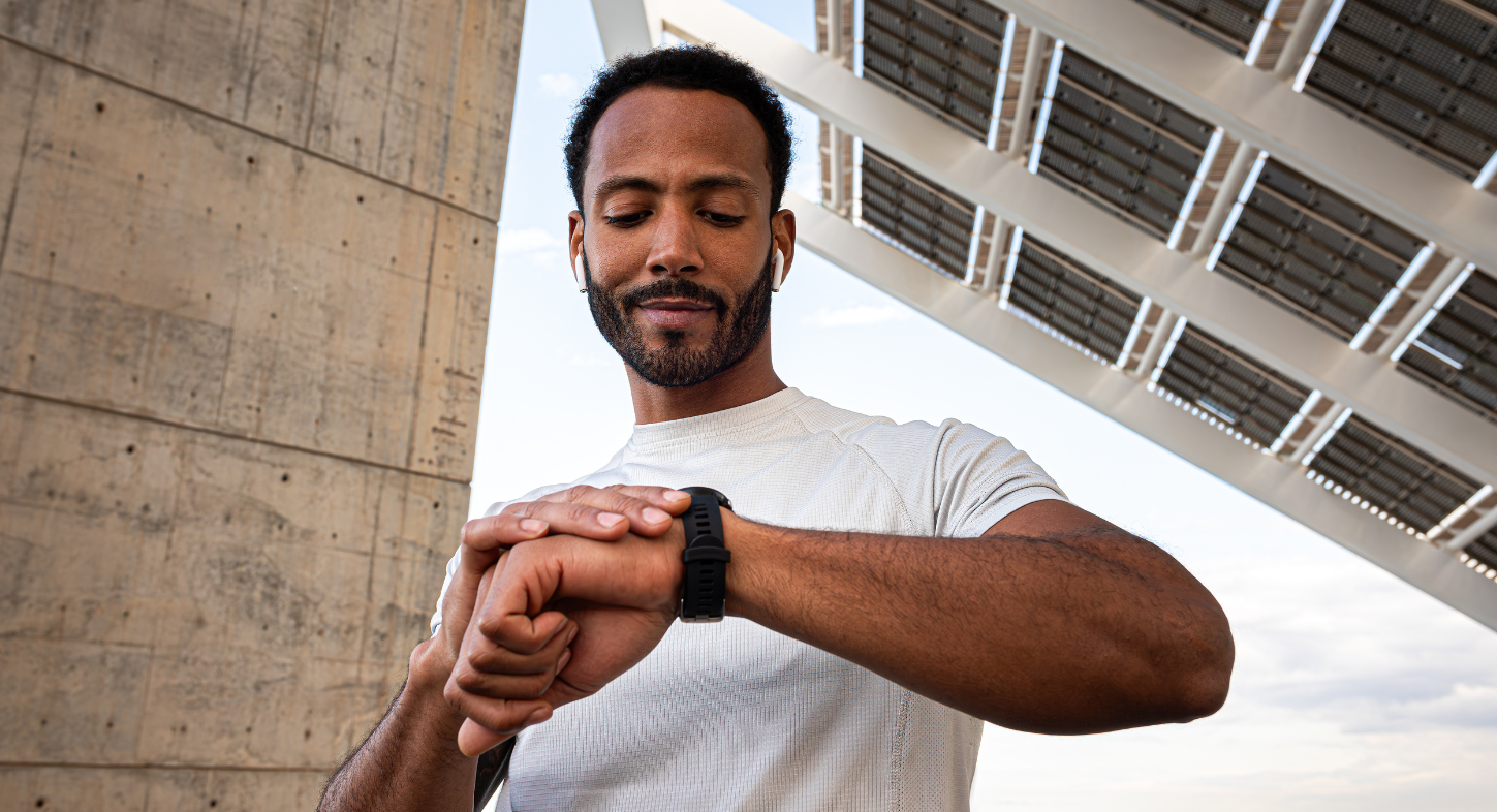 Man exercising using smart watch to track heart rate while listening to BPM and intensity-specific workout music in his fitness app
