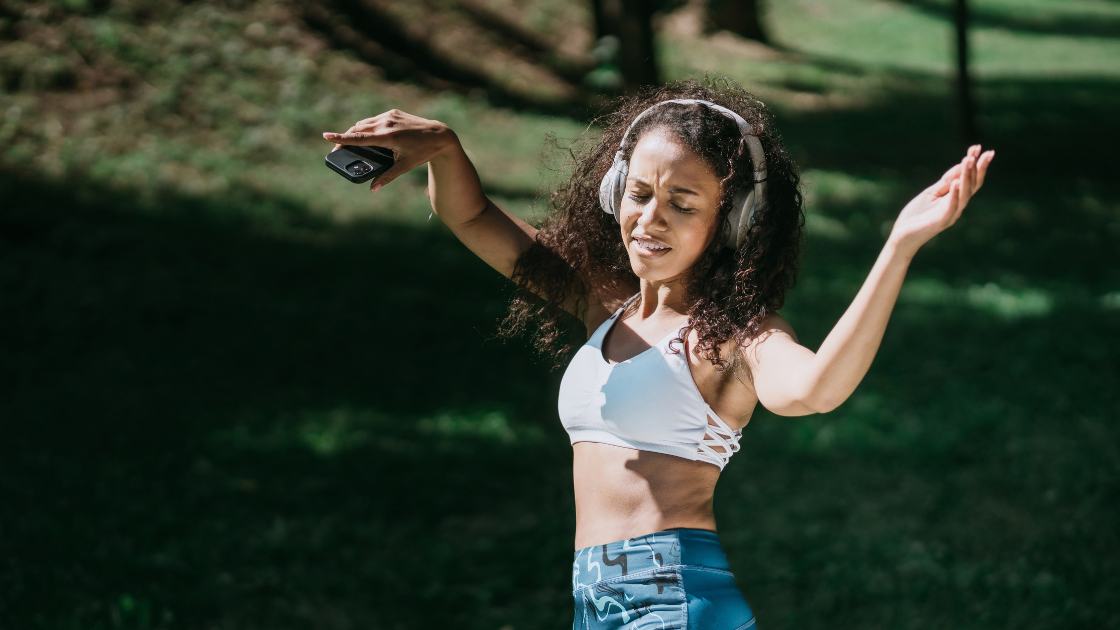 woman exercising to reggaeton music with headphones outside 