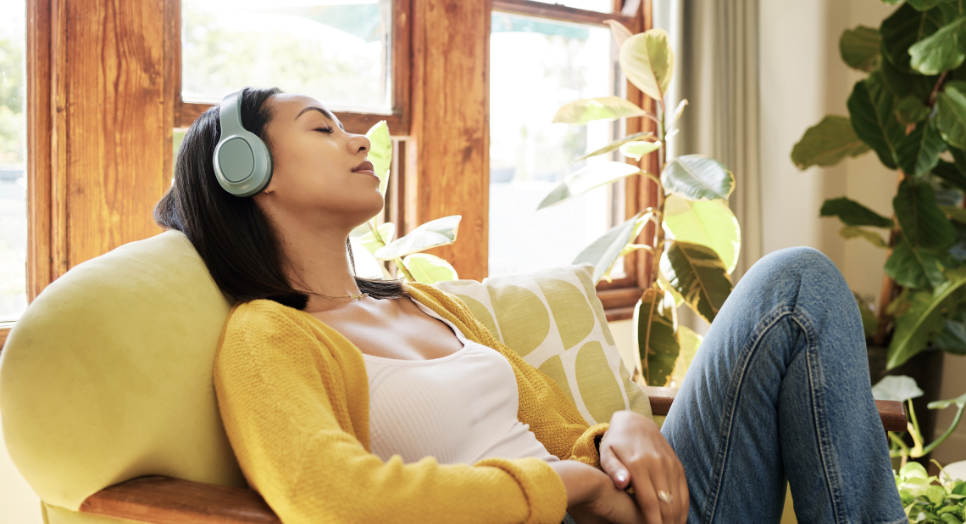 Woman listening to Feed.fm wellness soundtracks in wellness app