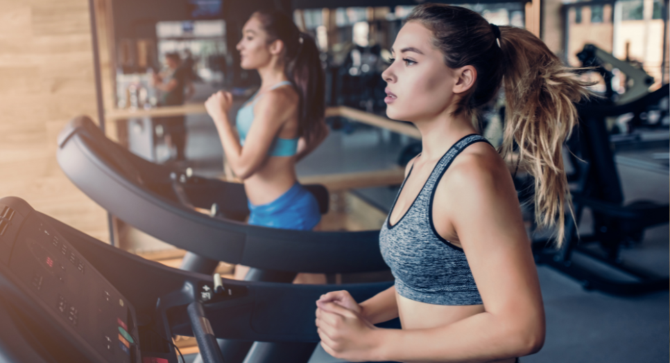two women working on in the gym while listening to feed originals 